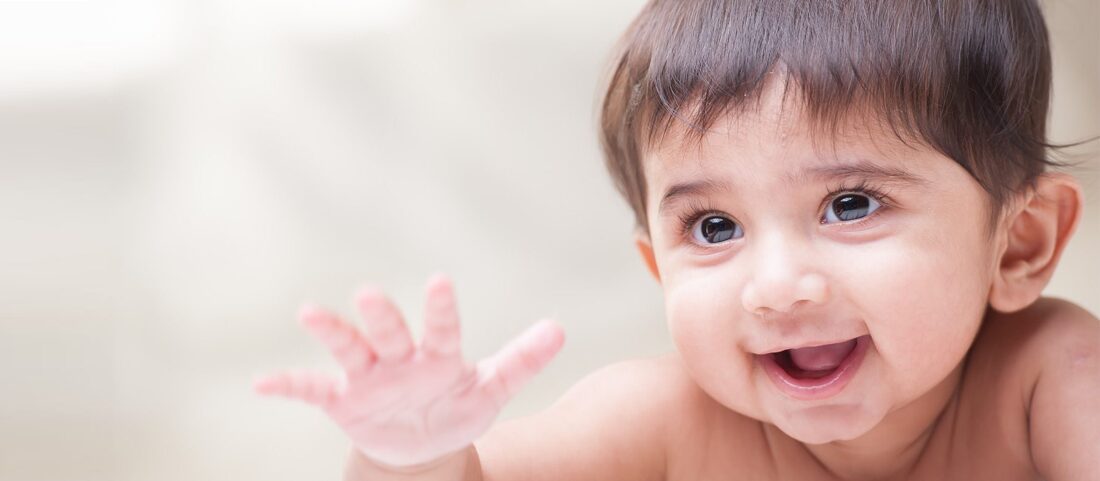 A baby with his hand up in the air.