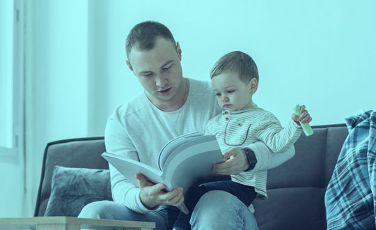 A man and his son are reading together.