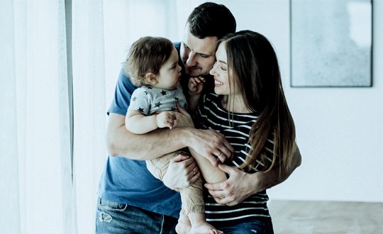 A man and woman holding a baby in their arms.