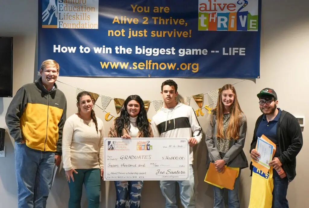 A group of people standing in front of a banner.